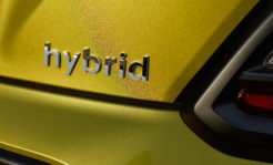 Chromed hybrid car logo on green background